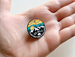 Camping Pin with Mountains and Sky Scene with Saying "Go Wild Adventure is Calling"